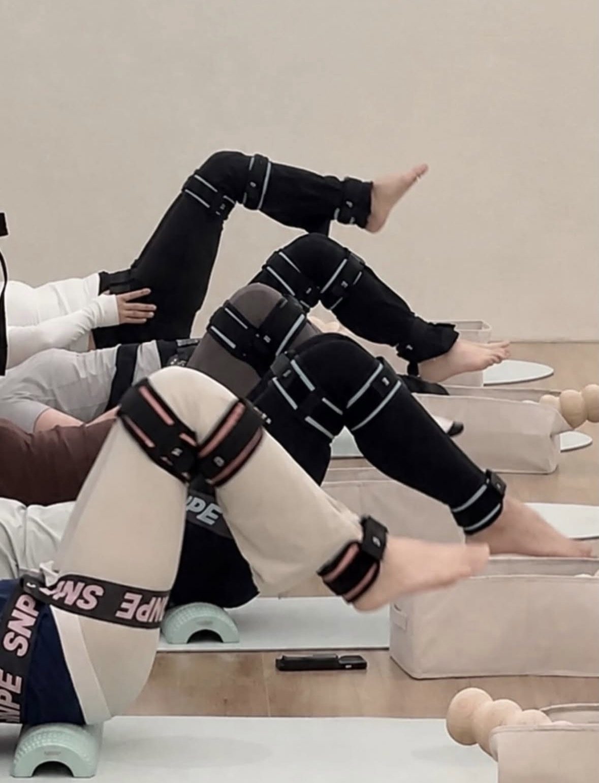 회원들이 나란히 누워 다리를 들어 올리는 그룹레슨